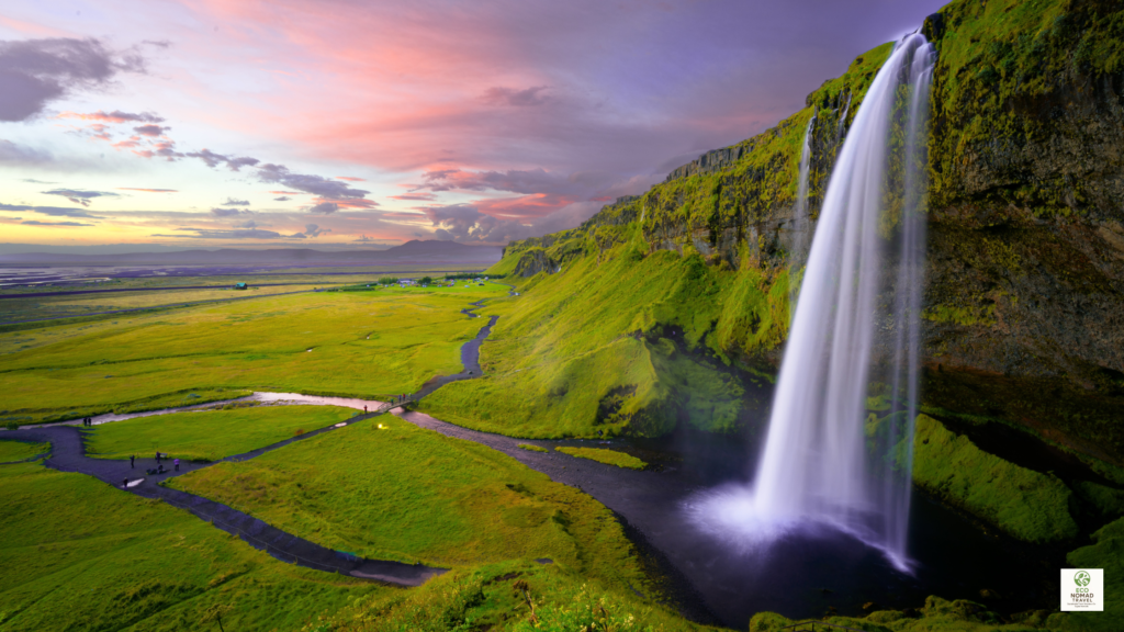 luxury in iceland at Seljalandsfoss waterfall with a tall cascade, misty spray, and a walking path behind the falls
