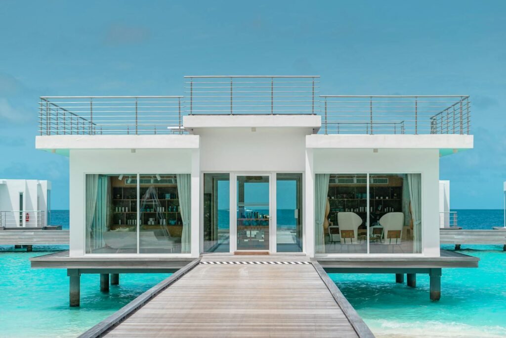 Cheval Blanc Randheli overwater luxury villa in the Noonu Atoll with a private deck above turquoise lagoon water.