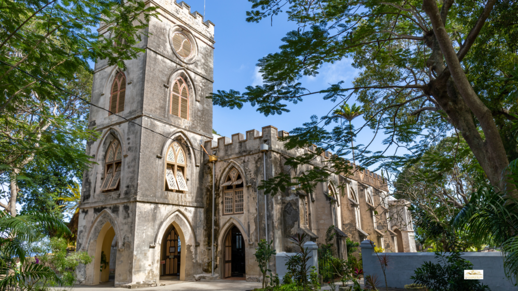 Best family island vacations: St. James Parish Church in Barbados with its historic stone exterior, arched windows, and tropical greenery under a bright sky.