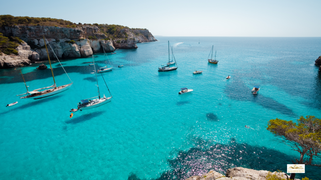 Boats on the ocean near Cala Marcella, Spain, with a rocky coastline, illustrating best mediterranean cruise itineraries.