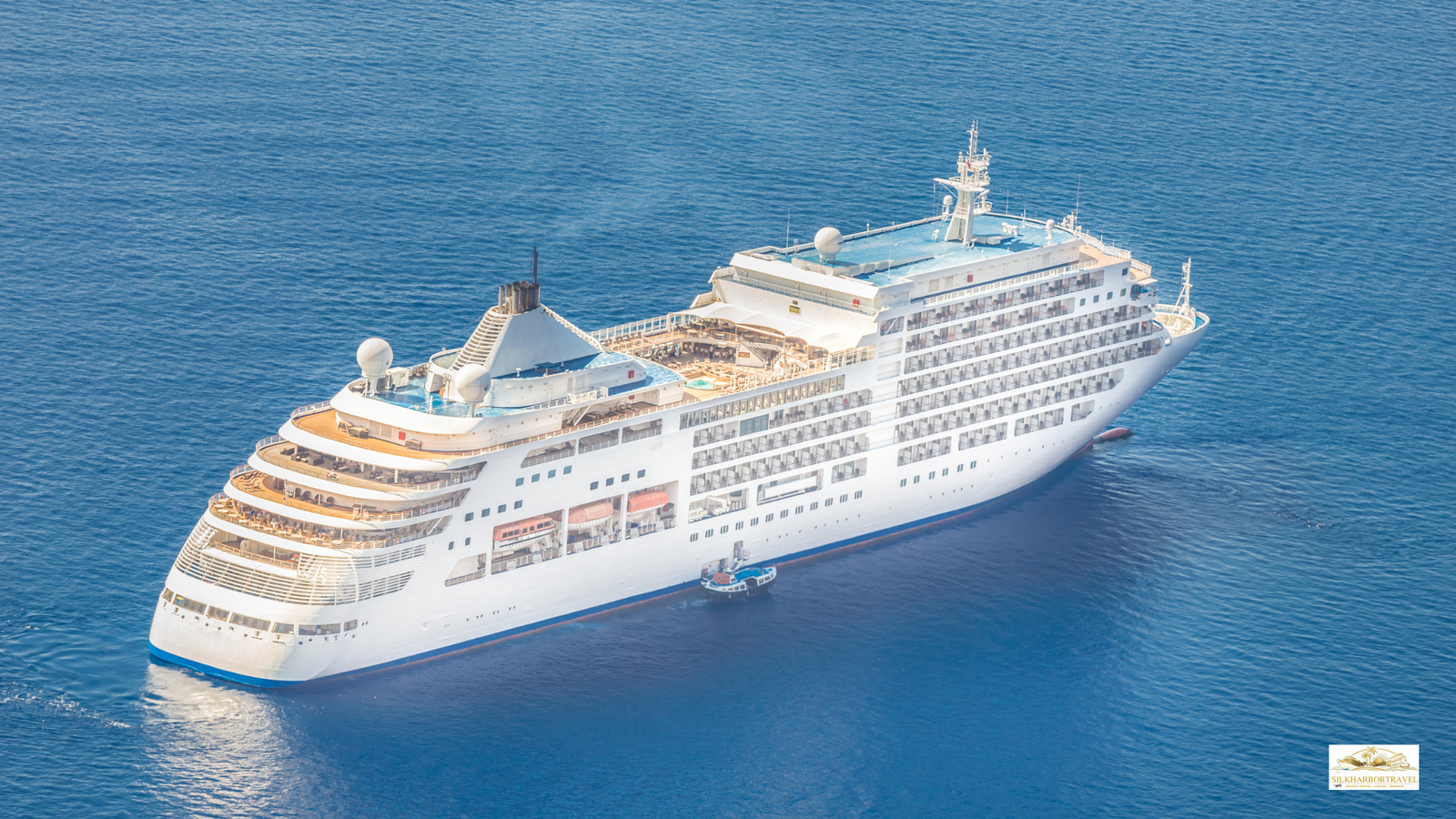 Luxury cruise ship sailing through the open ocean with a wide horizon and calm blue water