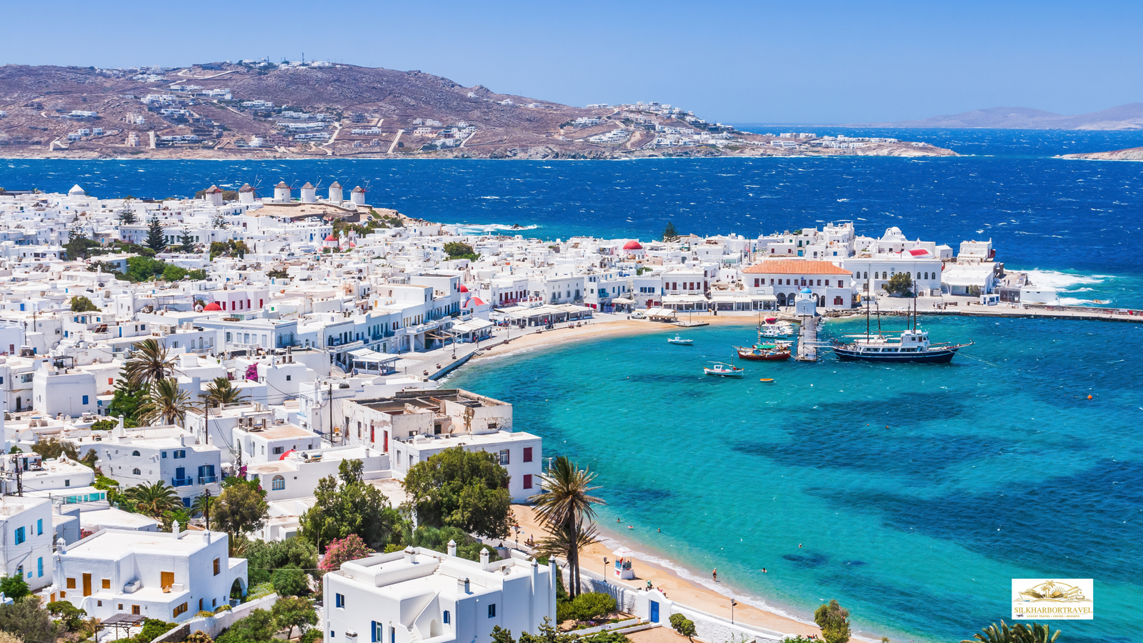 Luxury in Greece aerial view of Mykonos with vivid blue Aegean water and whitewashed buildings in bright daylight