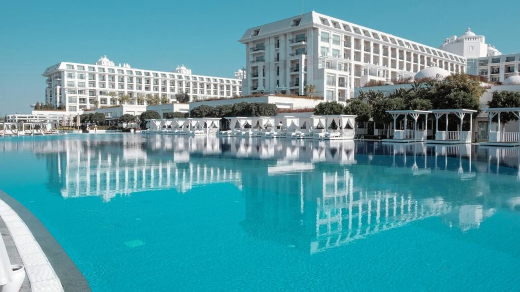 A premium resort facade reflected in a tranquil pool, evoking five-star atmospheres.