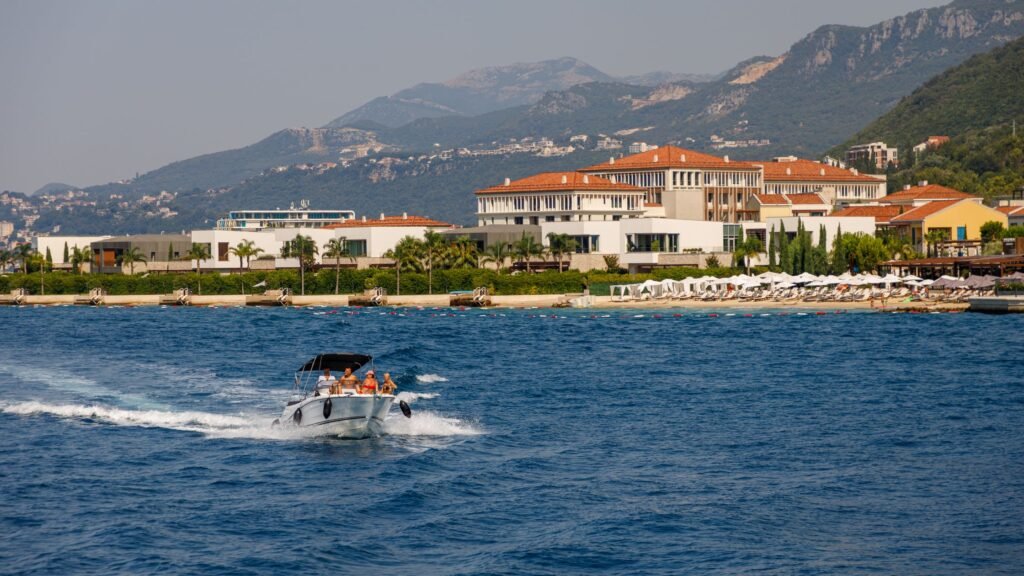 Featured image for luxury resort transfer options showing a boat cruising near a beachfront resort.