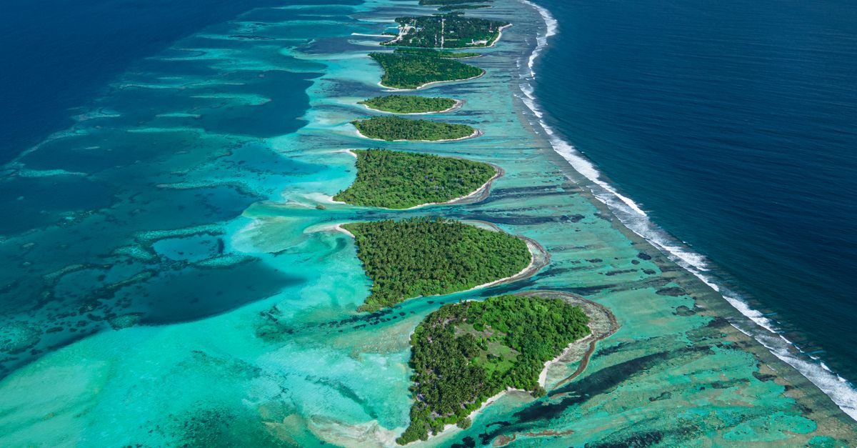 Aerial view of a turquoise lagoon ringed by coral reef