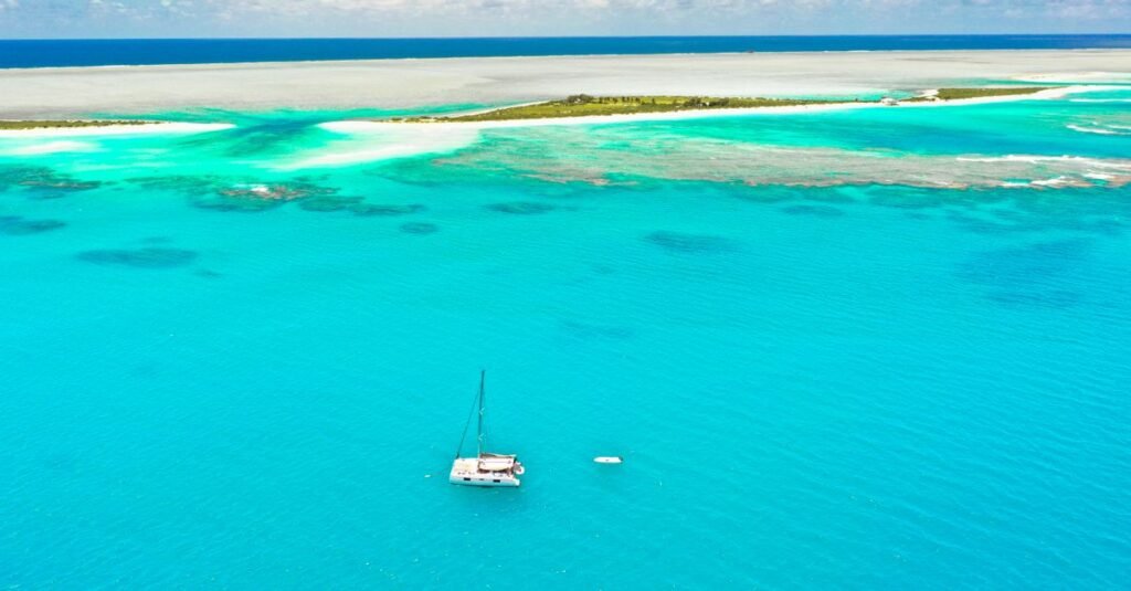 Catamaran anchored on a turquoise lagoon off a sandy beach