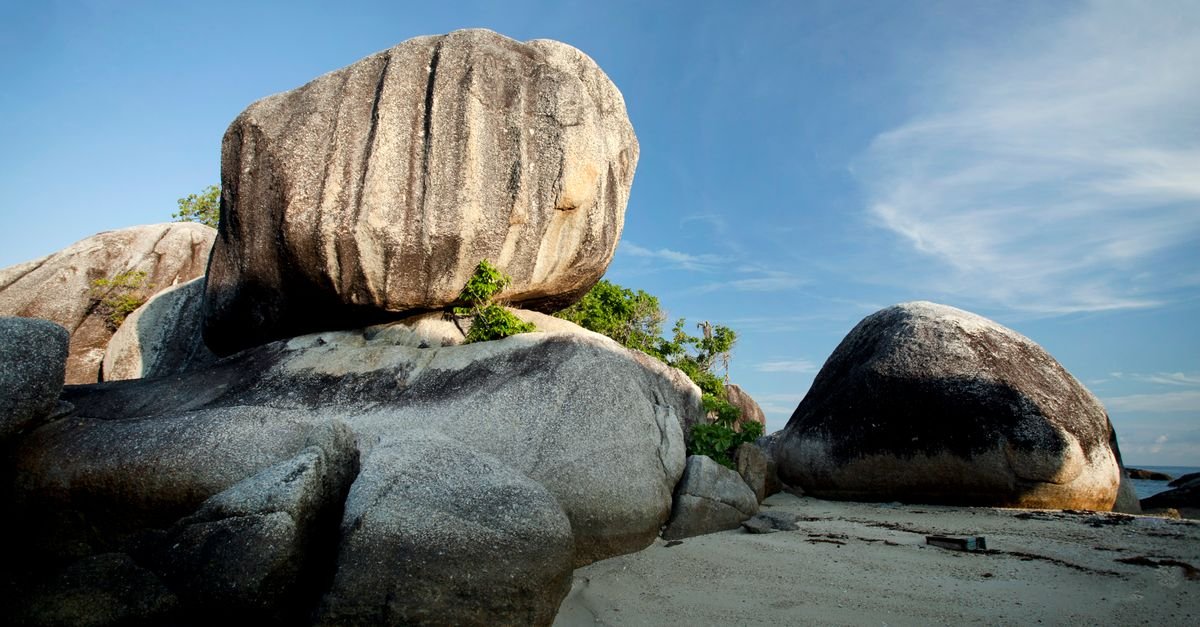 Granite boulders on a white sand tropical beach