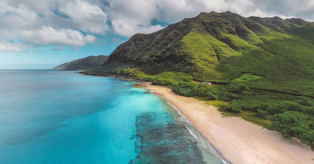 Aerial view of a green island coastline meeting turquoise water