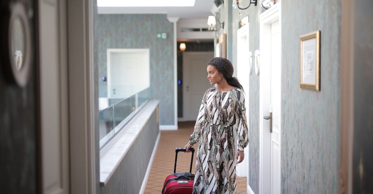 A lone traveller arriving at a hotel with a suitcase