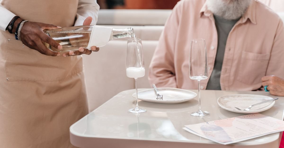A server placing a dish on a restaurant table
