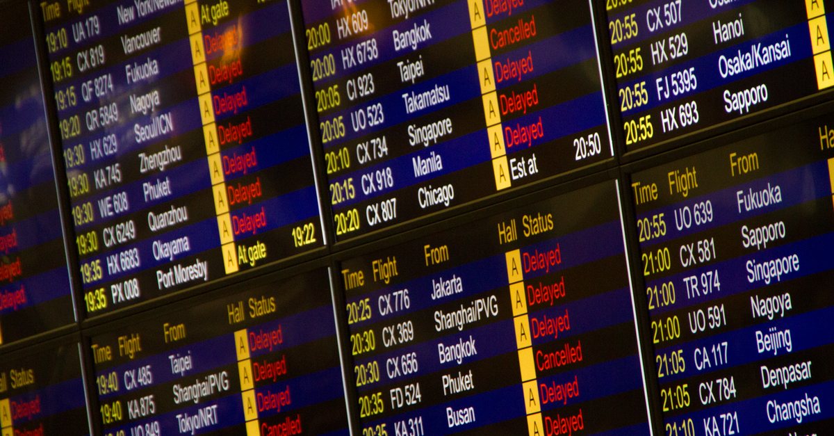 An airport departure board showing delayed flights